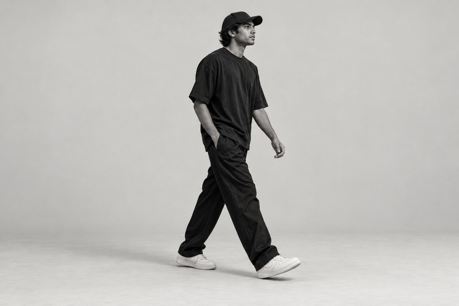 Sample editorial photograph of a model walking in relaxed black streetwear
